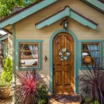 Cottage By The Sea Casa Carmela Entrance with arched wooden door and teal trim