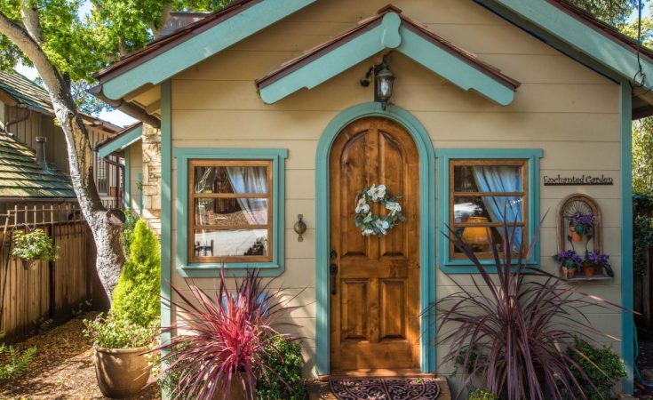 Cottage By The Sea Casa Carmela Entrance with arched wooden door and teal trim